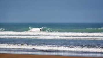 Una playa con olas y un surfista.