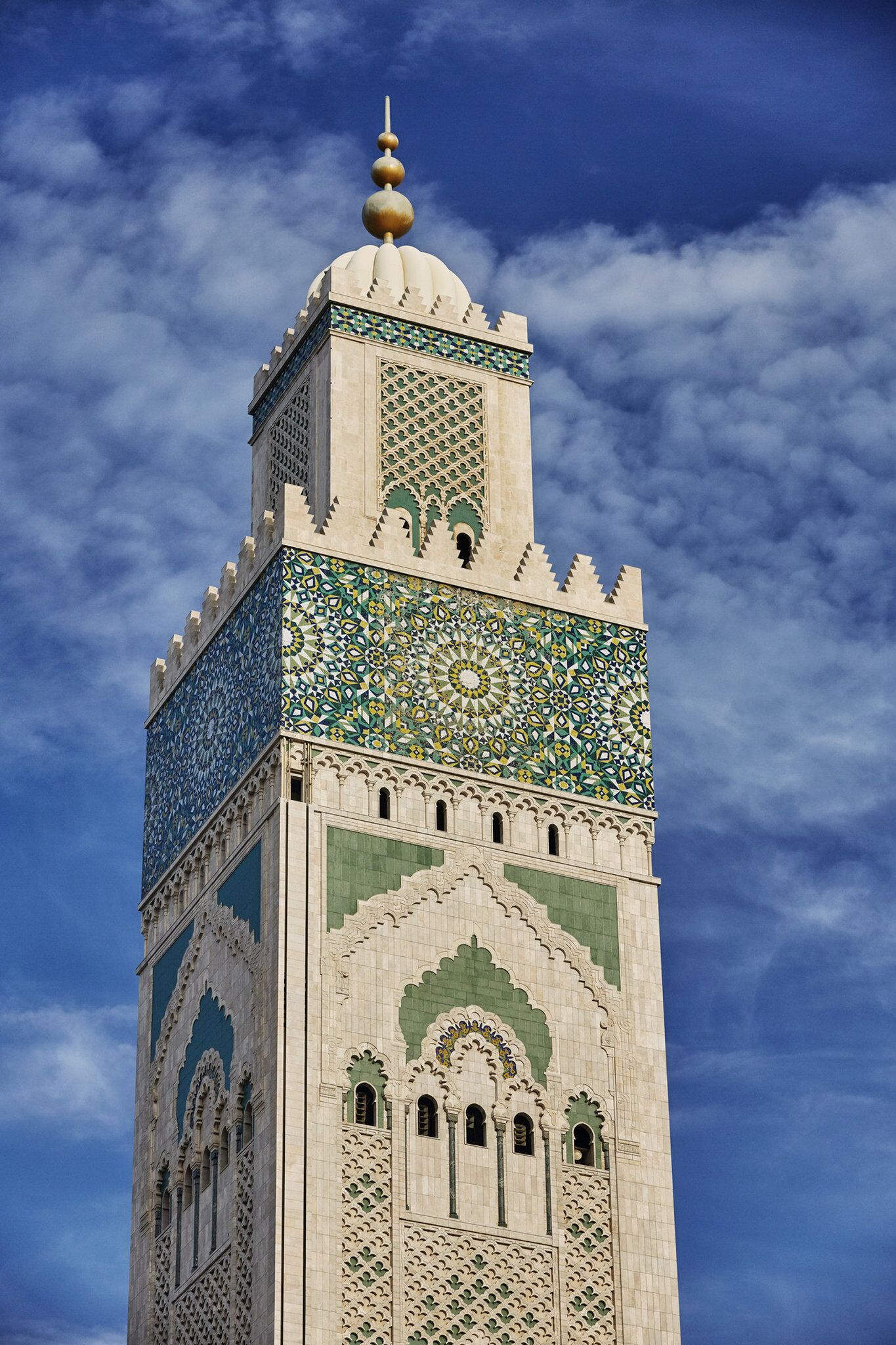 Ett högt minaret med detaljerat kakelarbete och en kupol på toppen.