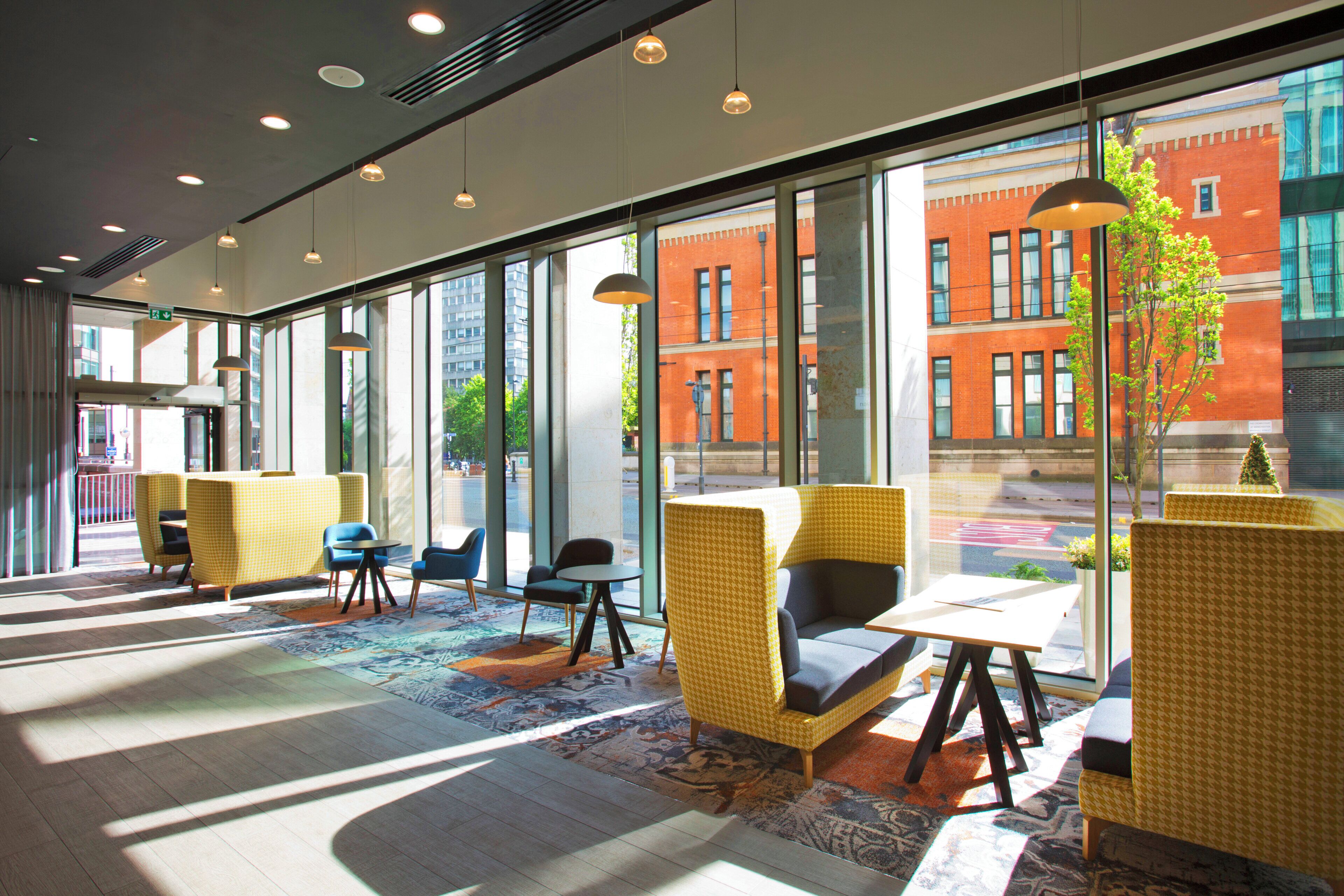 A modern interior with large windows, seating areas, and a patterned carpet.