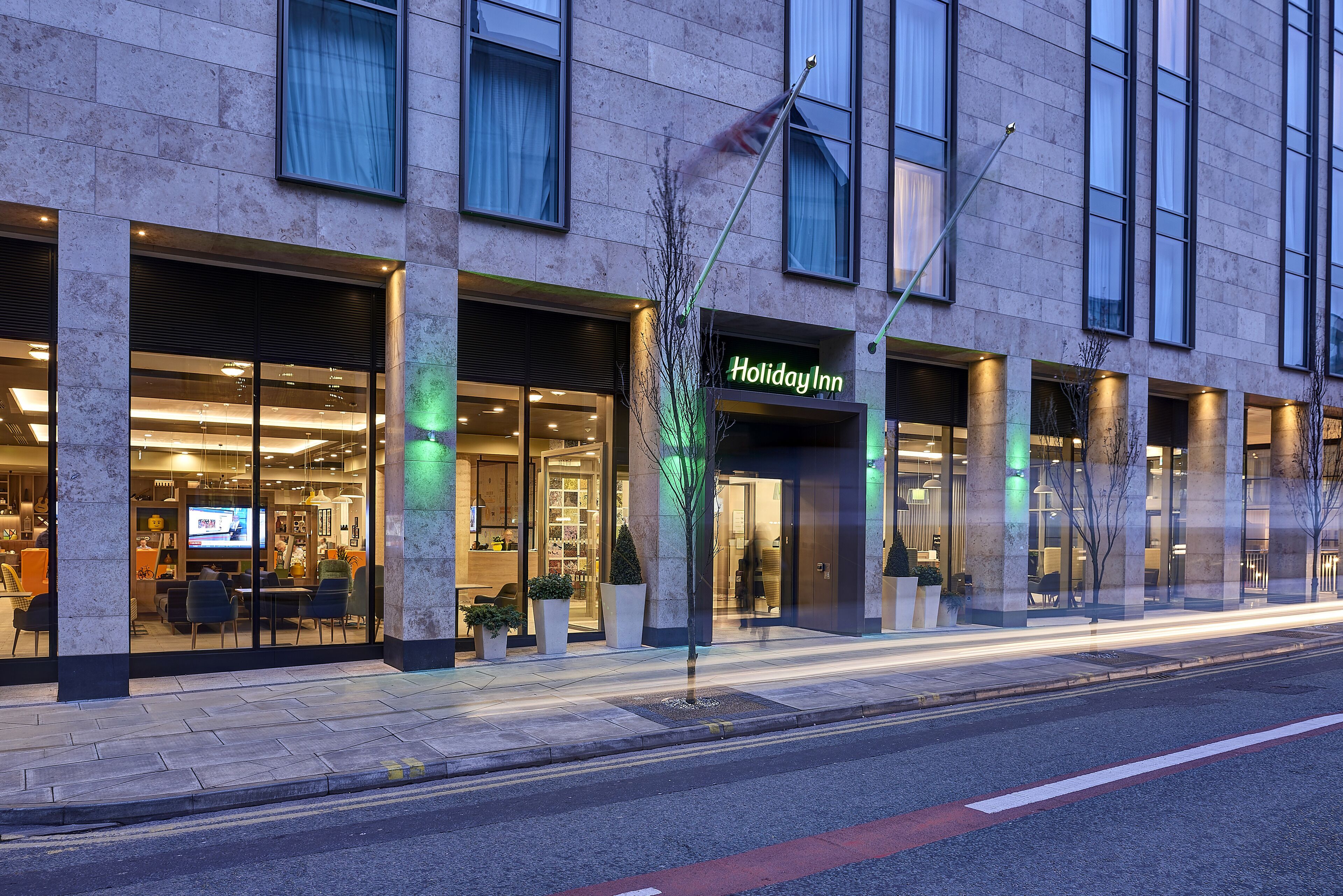 A Holiday Inn hotel with a modern facade, large windows, and a well-lit entrance.