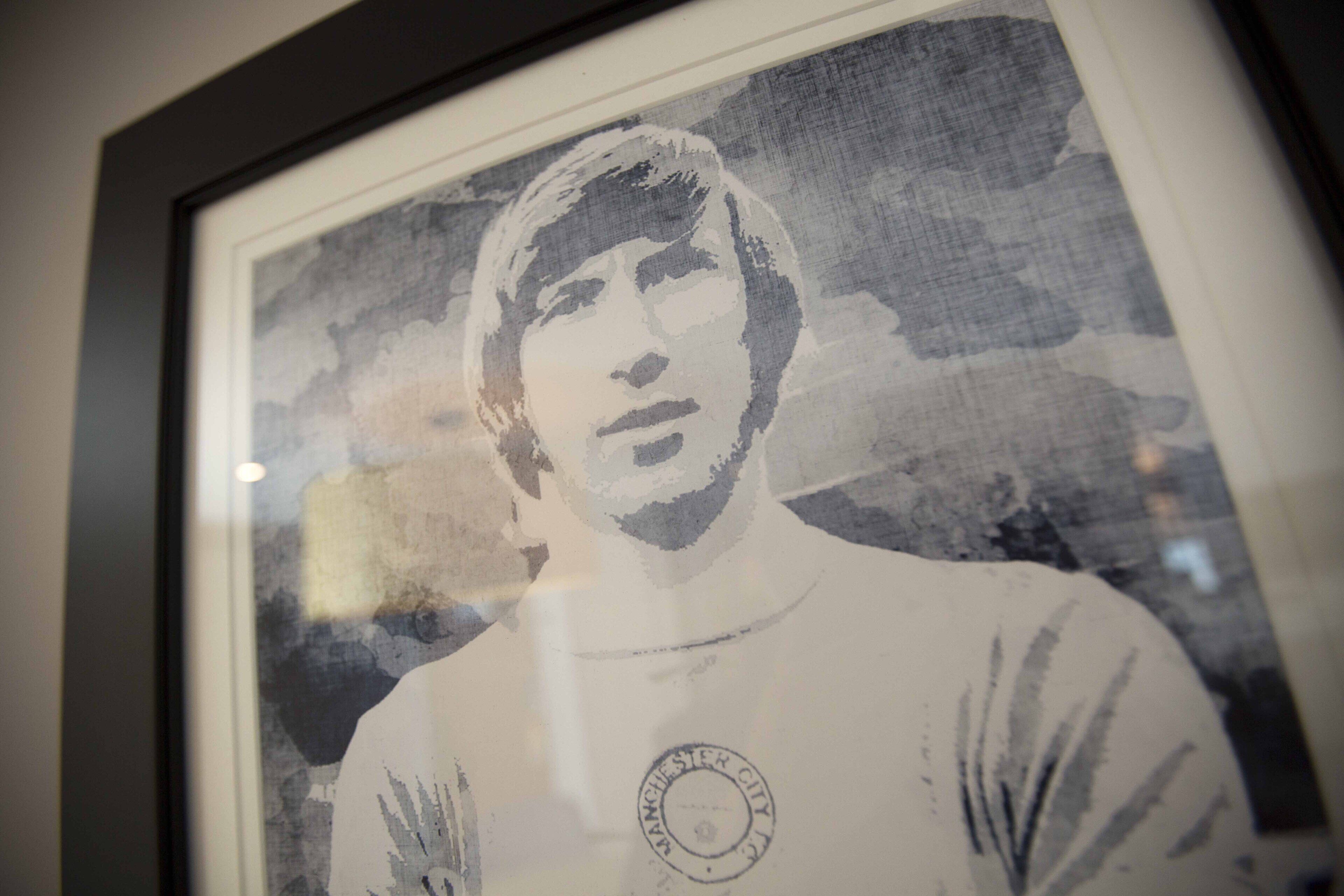 A framed portrait of a person wearing a shirt with a circular emblem.