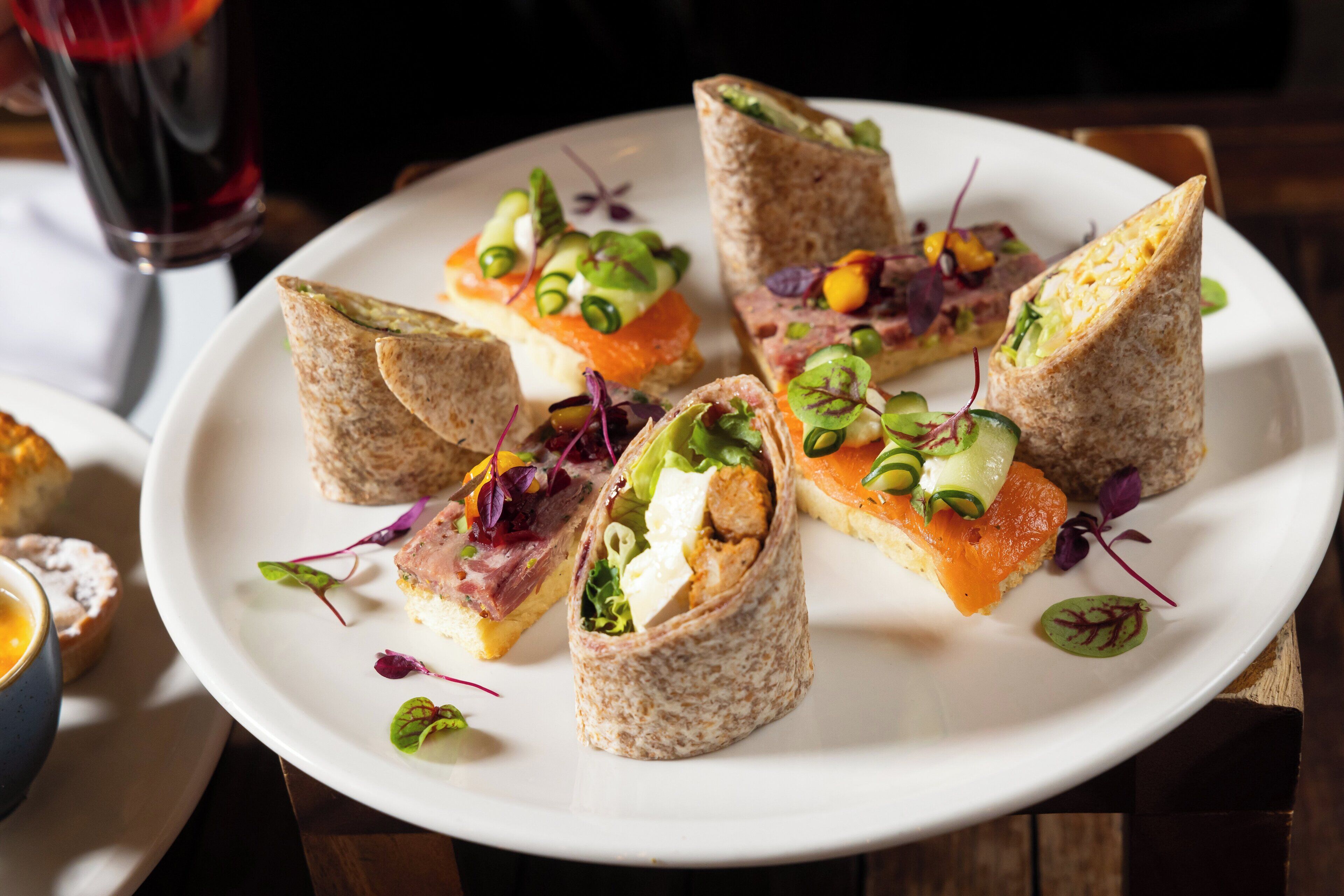 Une assiette de wraps garnis de divers ingrédients et accompagnés de différentes garnitures.
