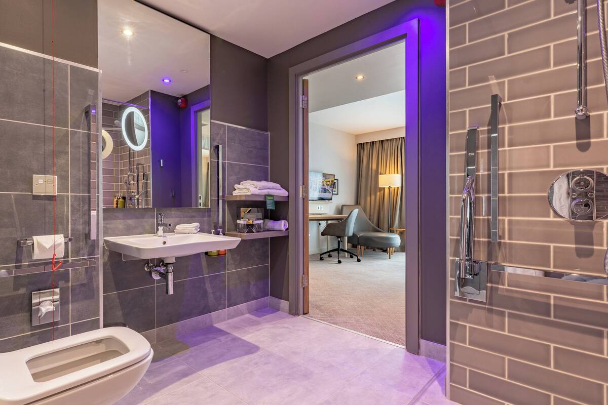 A modern bathroom with a toilet, sink, and shower.