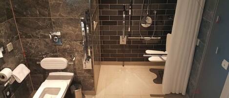 A modern bathroom with a toilet, bidet, and shower area.