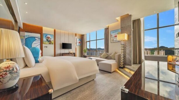 Une chambre d’hôtel moderne équipée d’un grand lit, d’un canapé, d’un bureau et d’une télévision.