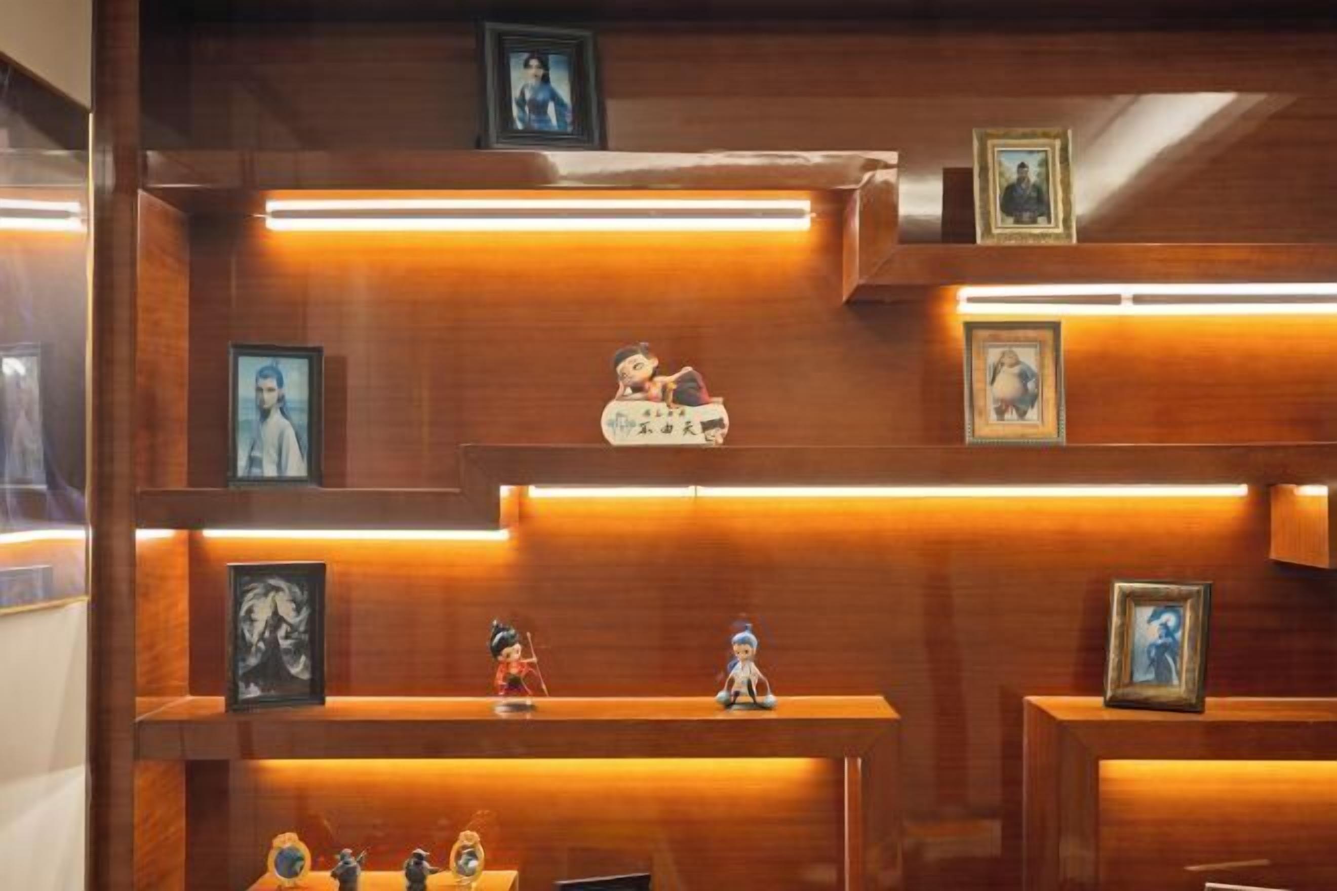A wooden wall with multiple shelves displaying framed pictures and figurines.