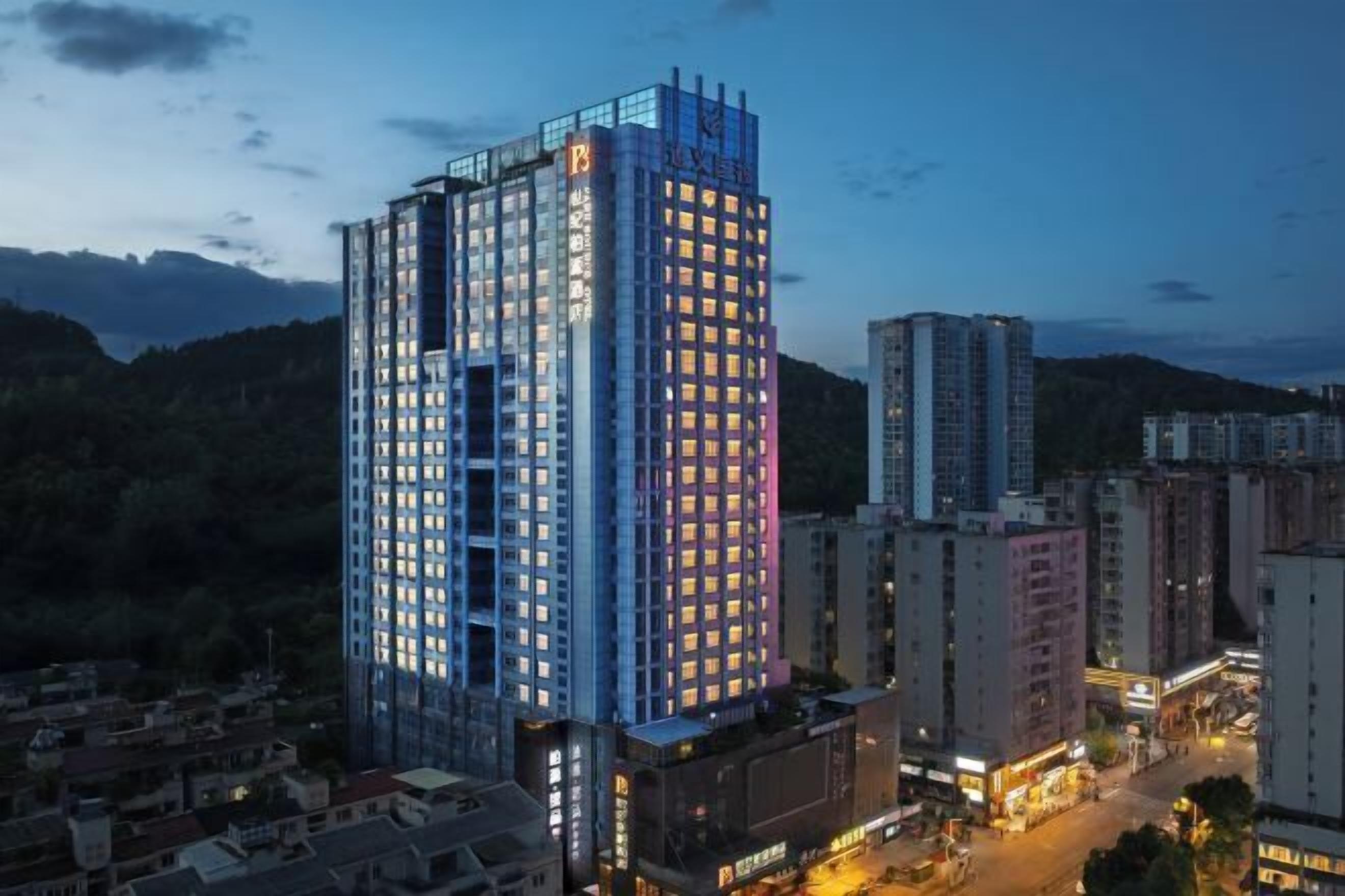 A high-rise hotel with multiple floors, a prominent entrance, and a view of the surrounding urban area.