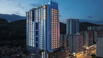 A high-rise hotel with multiple floors, a prominent entrance, and a view of the surrounding urban area.