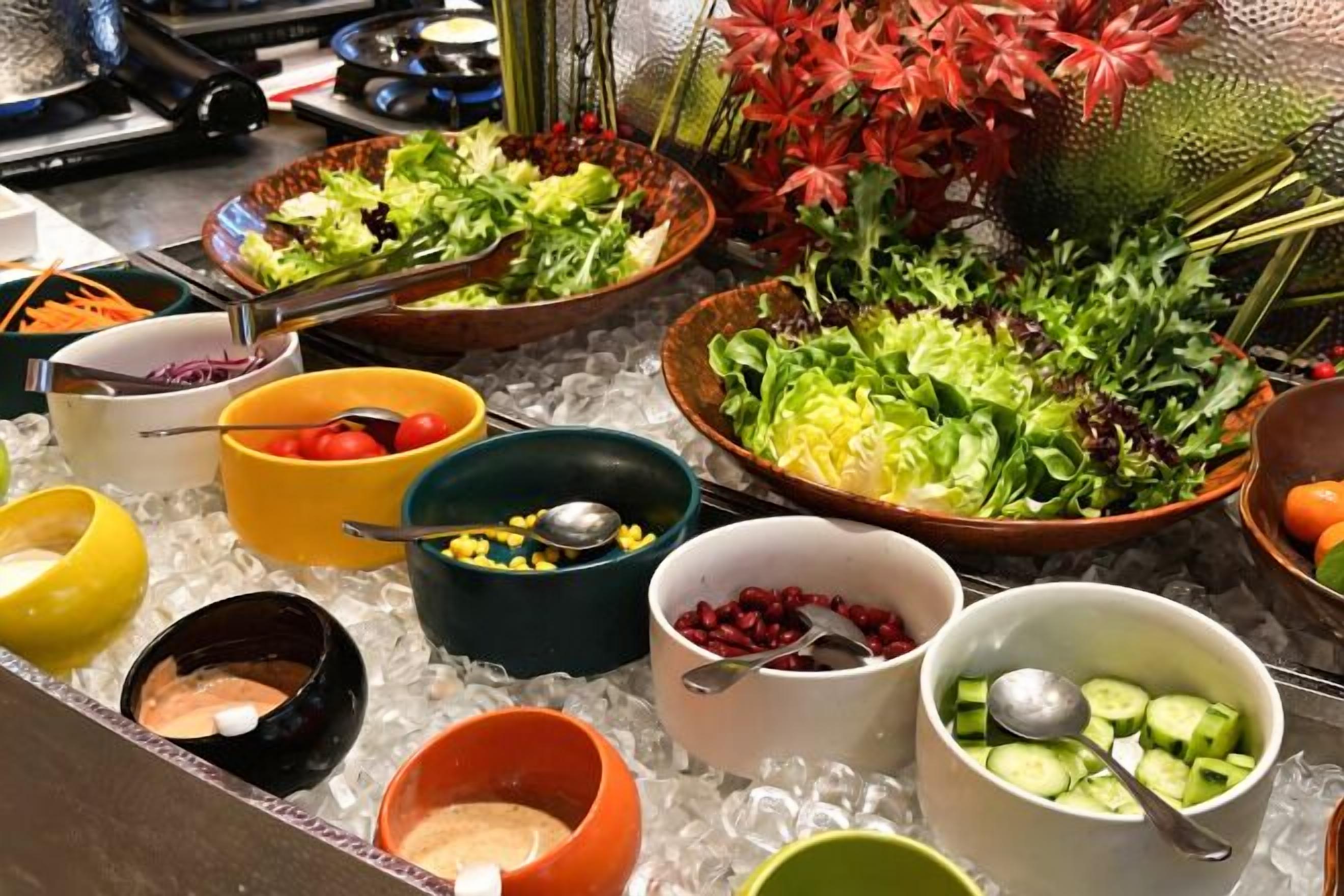 A buffet with various dishes and condiments.