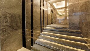 Un escalier en marbre doté d’un éclairage intégré, menant à un étage supérieur.