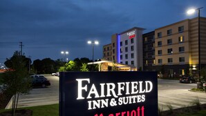Une enseigne indiquant l’emplacement du Fairfield Inn & Suites Marriott, offrant une vue dégagée sur l’entrée de l’hôtel et le parking.