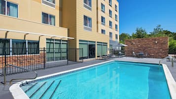 Una piscina al aire libre, sombrillas, sillones reclinables de piscina