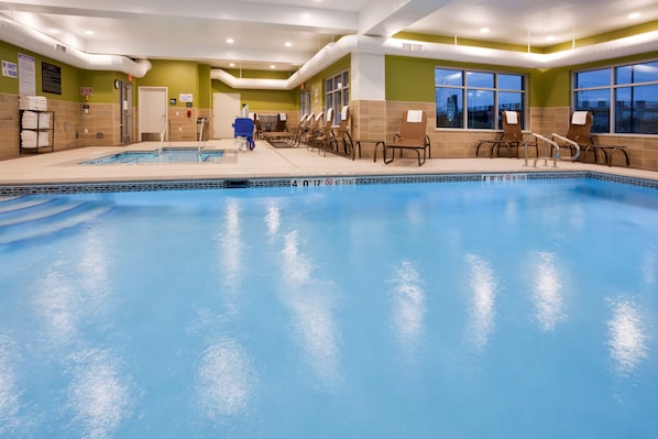 Una piscina techada, sillones reclinables de piscina