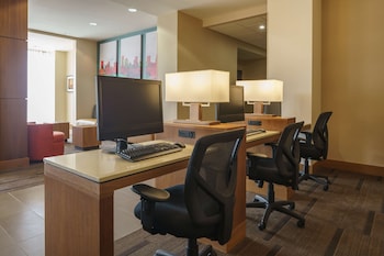 A conference room with a long table, chairs, a flat-screen TV, and large windows with sheer curtains. at Hyatt Place Houston/Galleria