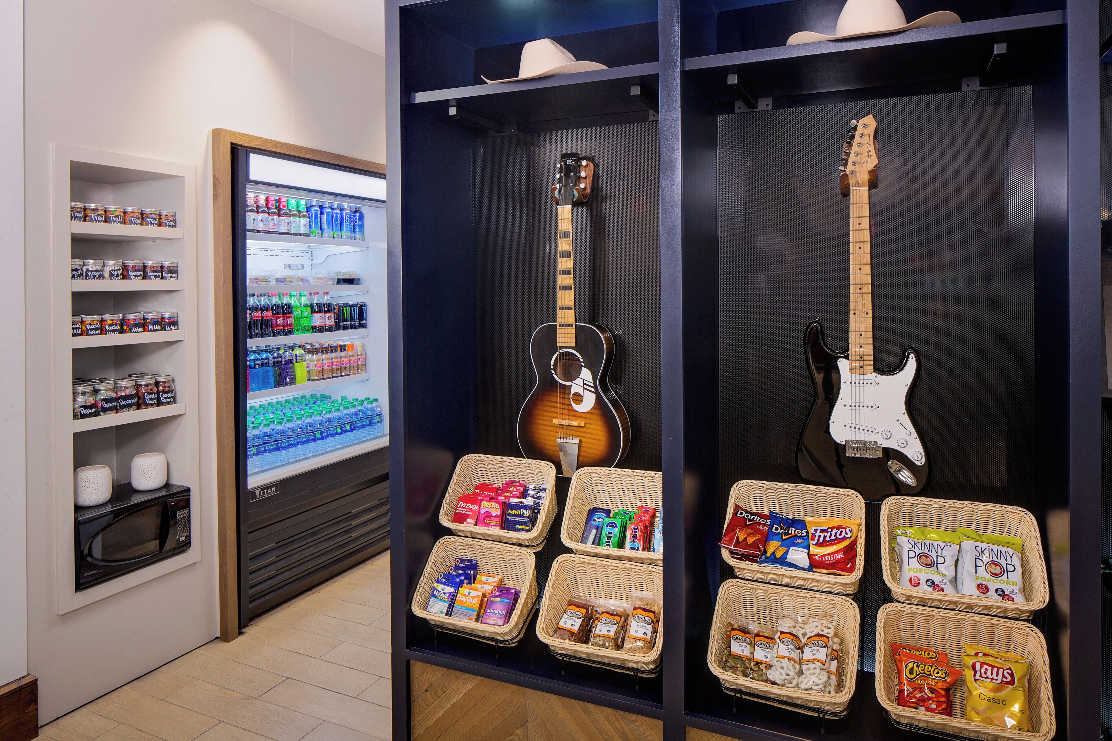 Una vitrina con aperitivos, una guitarra y un microondas.