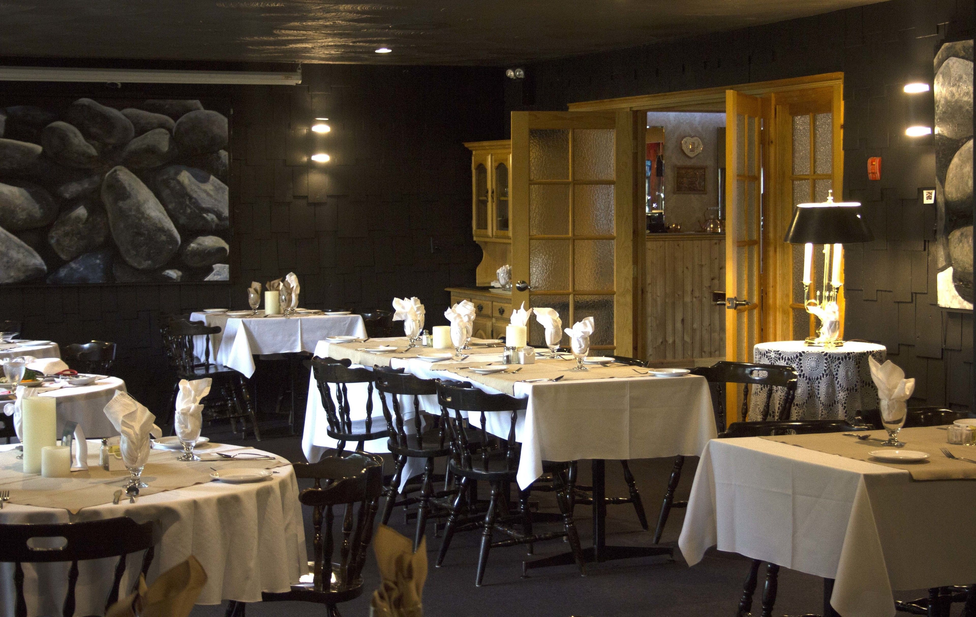 Restaurante con mesas redondas dispuestas para comer, con manteles blancos y velas.