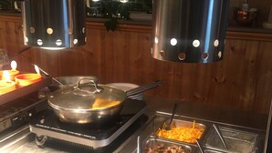 A buffet area with various food options including mushrooms, onions, cheddar, peppers, feta, and chives.