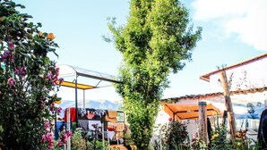 A cobblestone pathway leading to a building with a covered outdoor area. - Inkas Garden Apartment (Cusco)