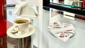 A hotel room with a glass table, a white teapot, and napkins. - Lo Scrigno B&B (Montemiletto)