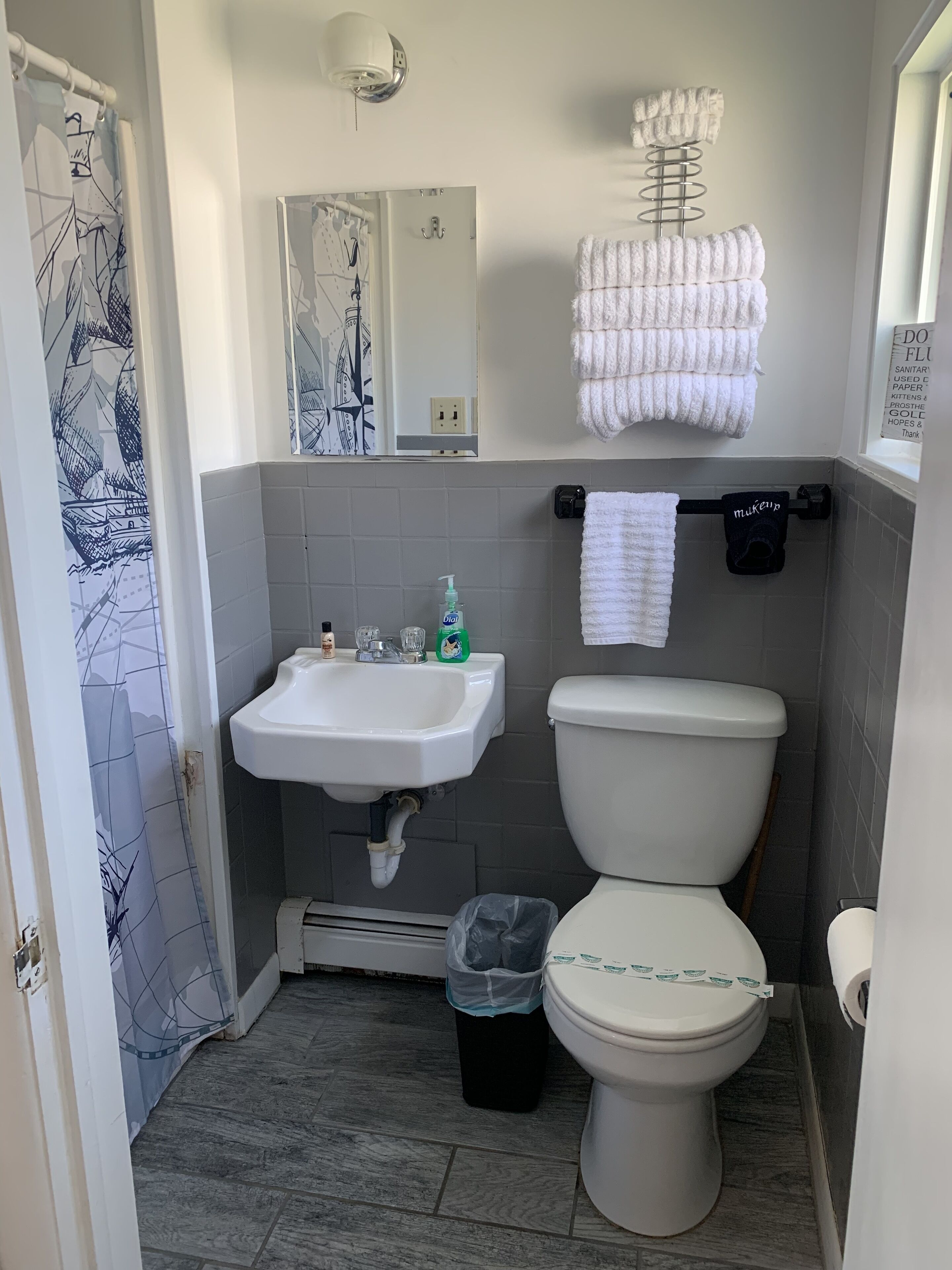 Un baño con lavamanos, inodoro y perchero para toallas.