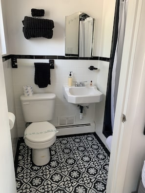 Ein kleines Badezimmer mit Toilette, Waschbecken und einem Spiegel darüber.