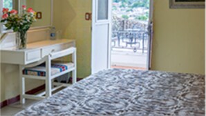 Un dormitorio con cama, cómoda, espejo y puerta que da a un balcón.