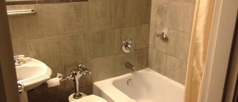 Un baño con inodoro, lavamanos y bañera.