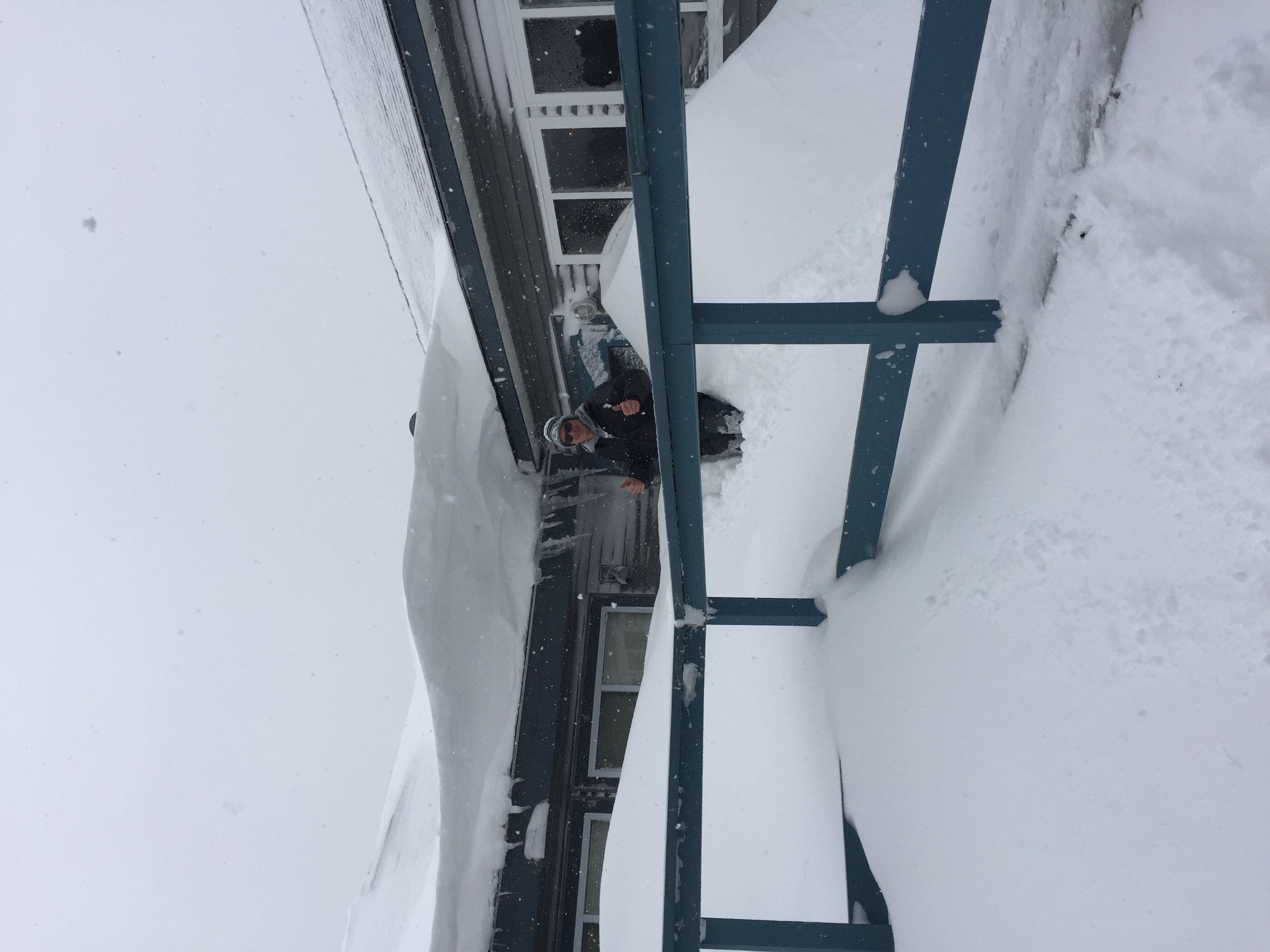 A narrow snow-covered pathway with a metal railing.