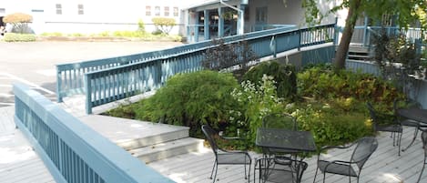 A wooden deck with outdoor seating and a blue railing.