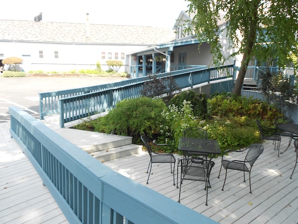 A wooden deck with outdoor seating and a blue railing.