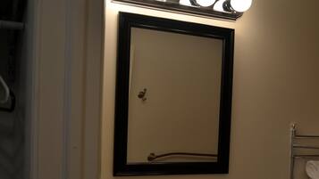 A bathroom with a sink, mirror, and towel rack.