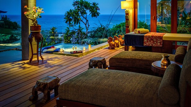 A wooden deck with a hot tub, seating area, and a view of the ocean. - Private Villas of Bali (Kutuh)