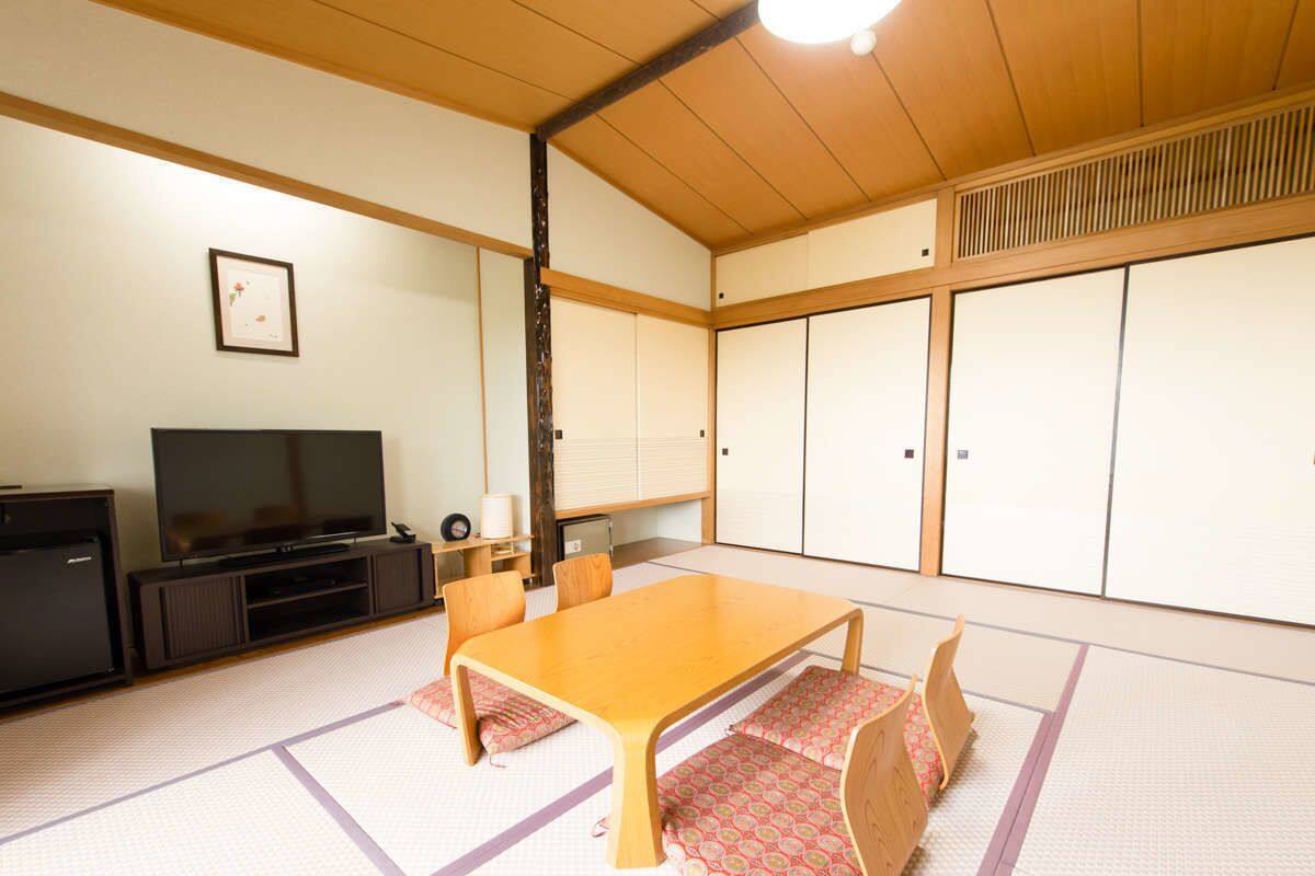 A traditional Japanese room with tatami flooring, a low wooden table, and sliding doors.