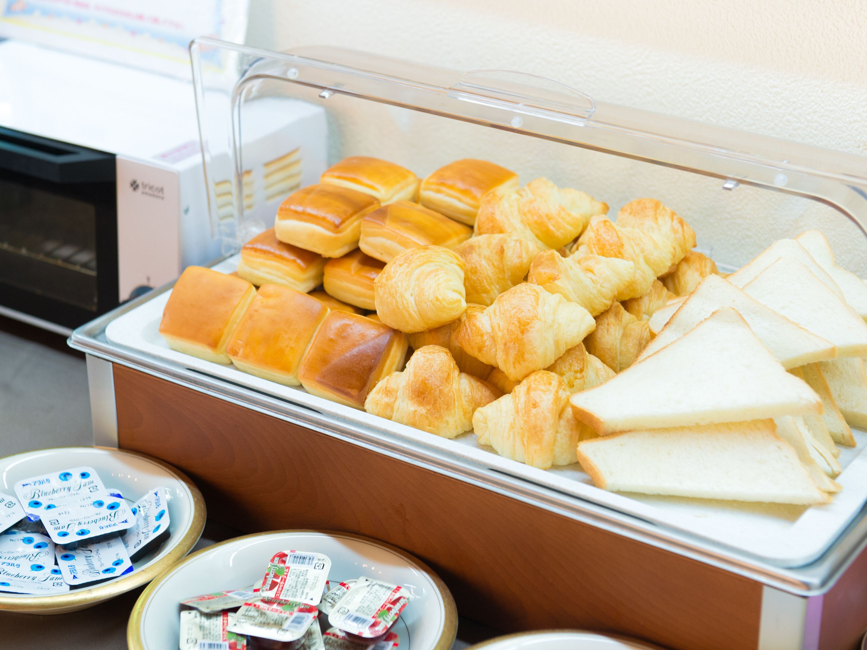 Un bufé con diversas opciones de panadería, incluyendo pan y pastelería.