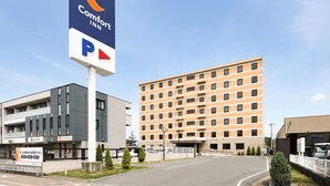 A Comfort Inn hotel with a parking sign, modern buildings, and a clear sky. - Comfort Inn Ogaki (Ogaki)