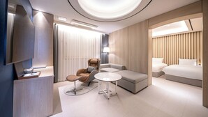 A modern hotel room with a sofa, armchair, bedside tables, and a bed. - Hound Hotel Gwangju Cheomdan (Gwangju)
