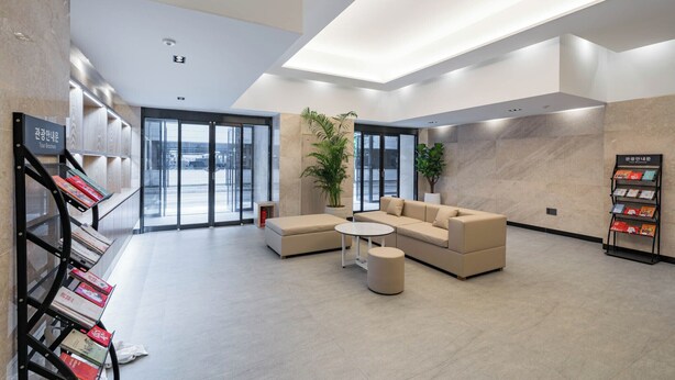 A modern lobby with a sofa set, a small table, and a bookshelf with books. - Hound Hotel Gwangju Cheomdan (Gwangju)