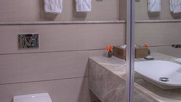Ein modernes Badezimmer mit Toilette, Waschbecken und Spiegel.