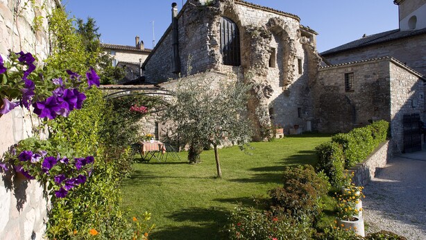 An old stone building with a garden in front. - Il Turrione Appartamenti Vacanze (Assisi)
