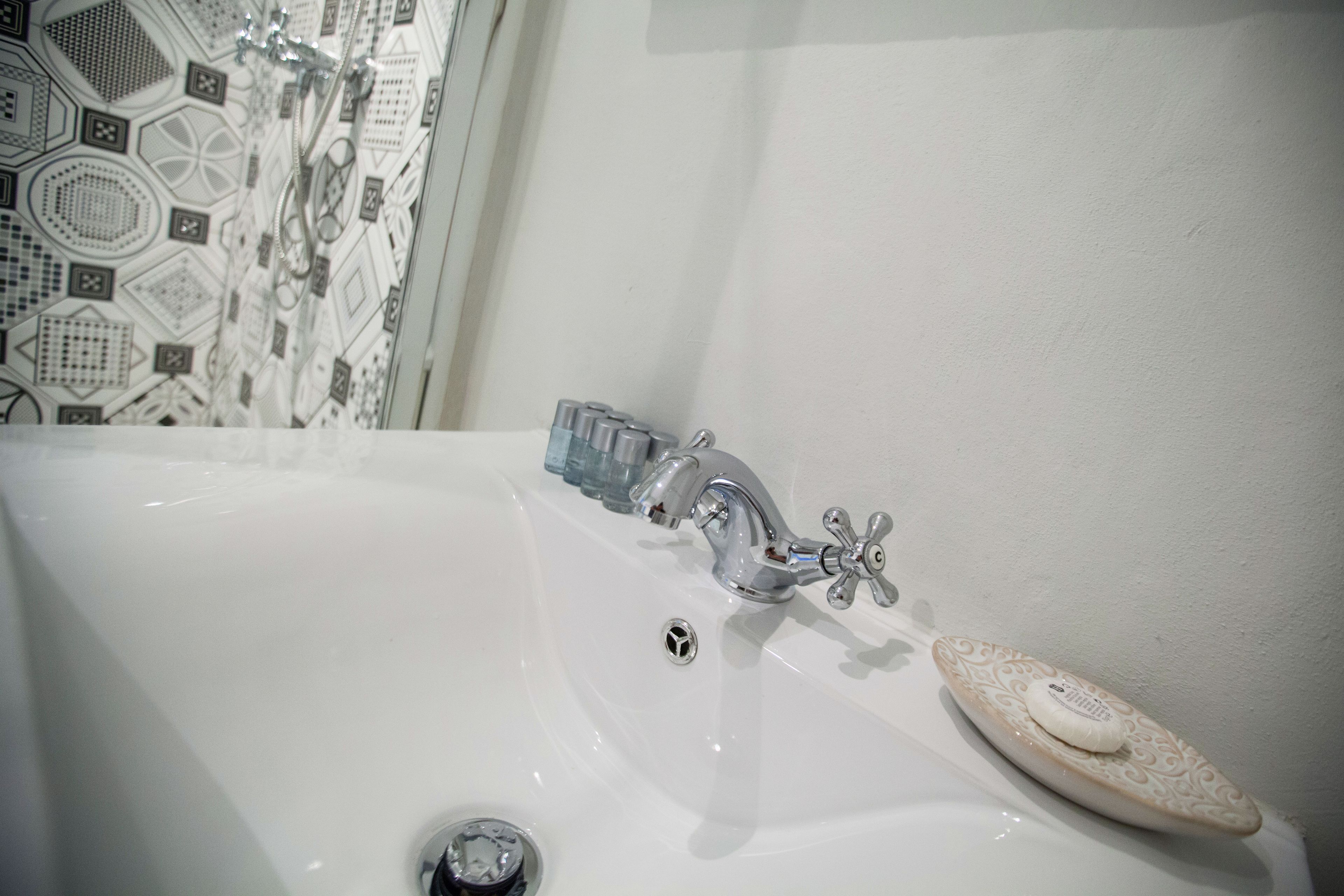 A white bathtub with a modern faucet and a soap dish.