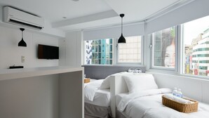 A modern hotel room with a bed, bedside table, and a TV. - Poshpacker Hotel (Taipei)