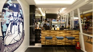 A bar area with a counter, stools, and a bartender. - Poshpacker Hotel (Taipei)