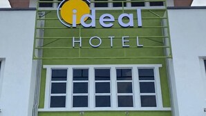 Un hotel llamado 'ideal' con fachada verde y ventanas blancas.