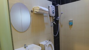 Un baño con inodoro, bidé, lavabo y un perchero para toallas.