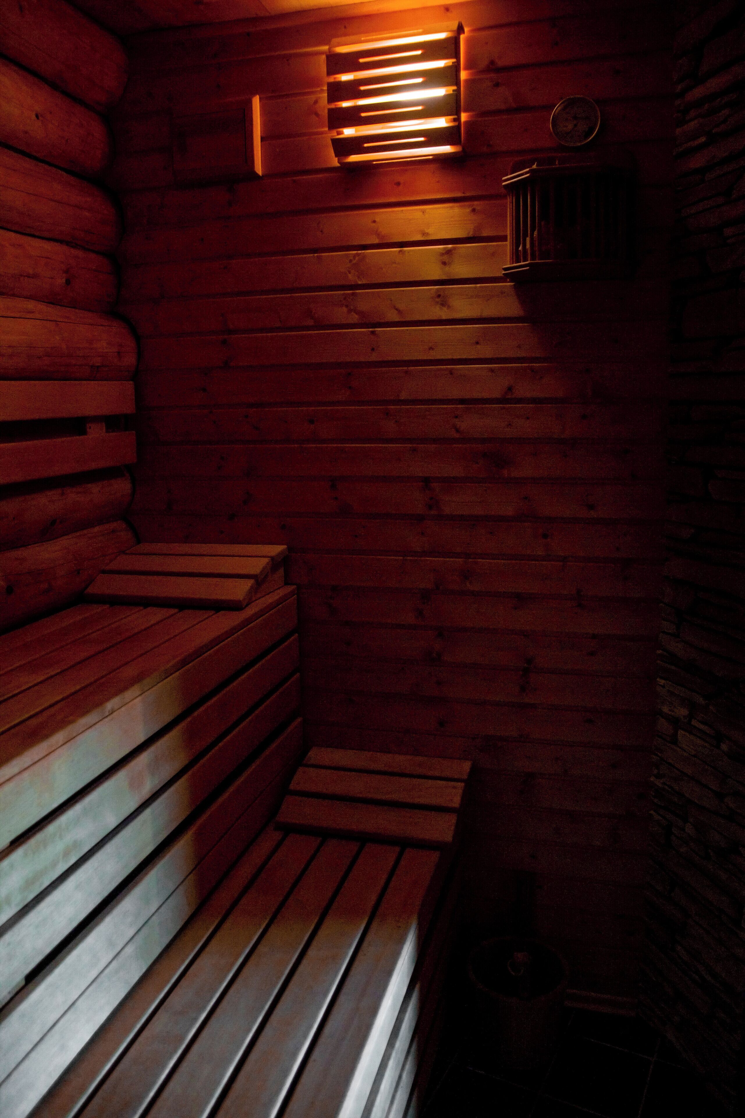 Een sauna met houten banken en een schuine hemel.