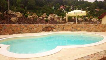 Alberca al aire libre y camastros