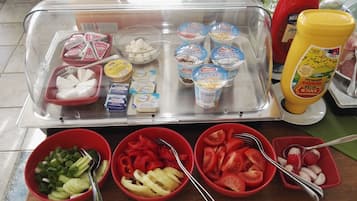 A buffet setup with various food items and condiments.
