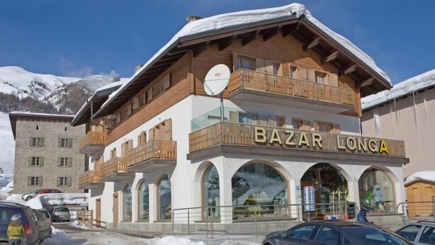 A multi-story building with a wooden facade and balconies, labeled "BAZAR LONGA". - Residence Casa Longa (Livigno)