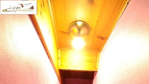 A narrow hallway with pink walls and wooden flooring leading to a staircase. - Residence Casa Longa (Livigno)