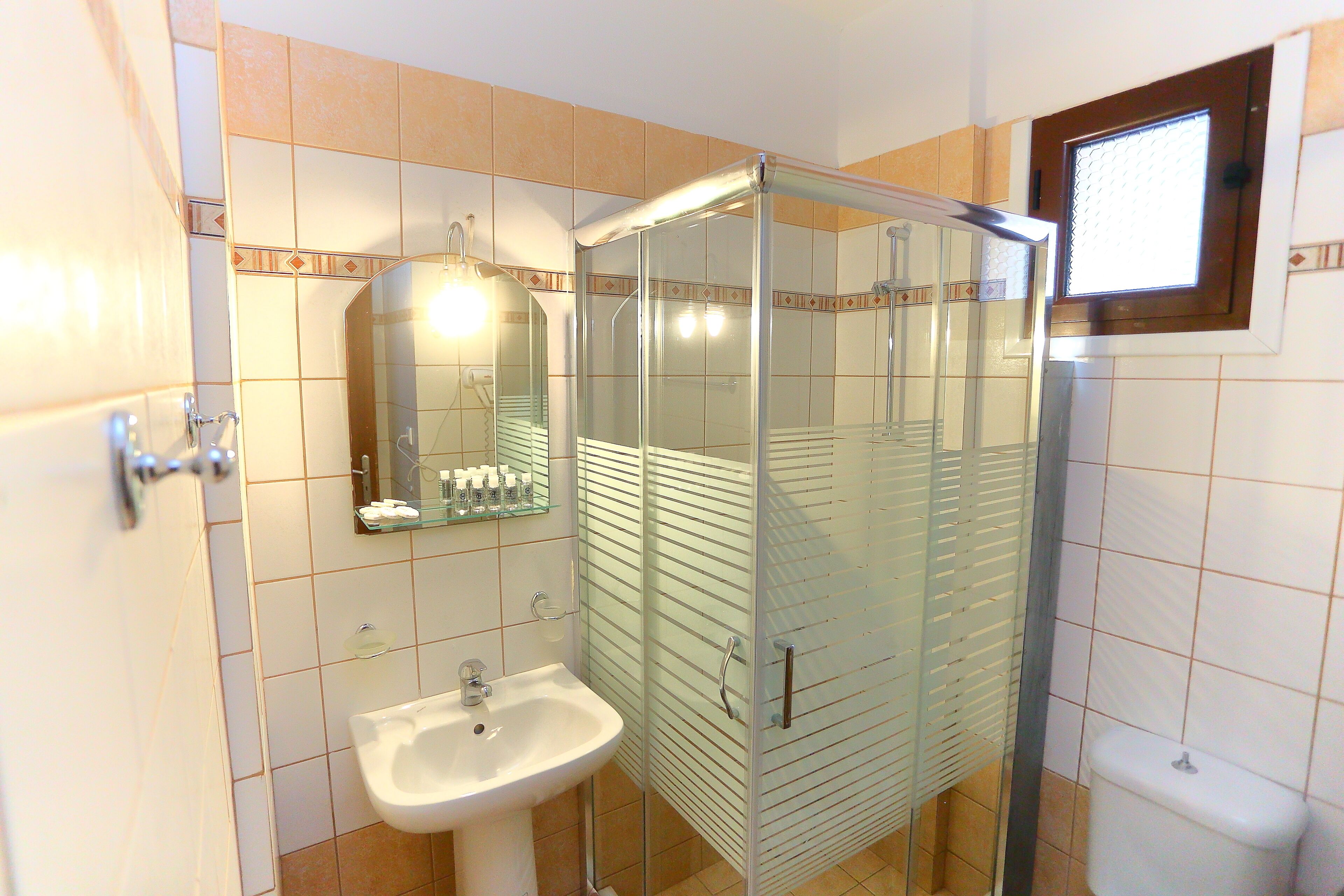 Un baño con cabina de ducha de vidrio, un lavabo y un espejo.